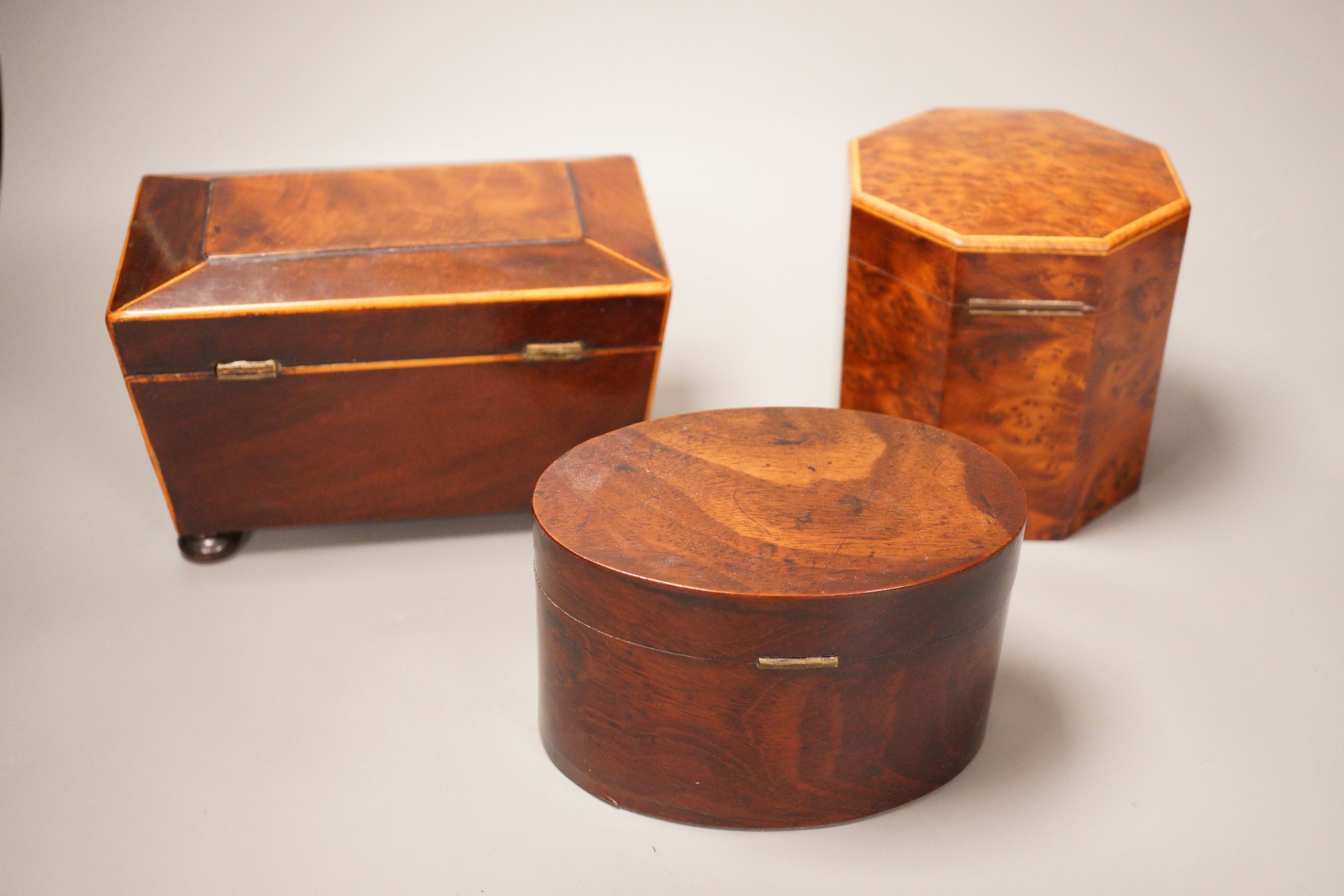An oval mahogany box (with key), an octagonal amboyna tea caddy and a boxwood edged mahogany tea caddy, 19th century 20cm wide
